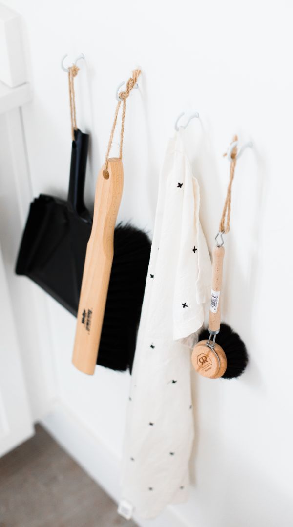 brush and dustpan hanging in kitchen